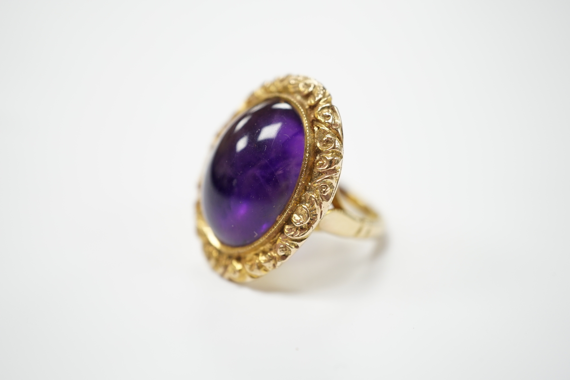 A 1970's Victorian style 9ct gold and cabochon amethyst set oval dress ring, size J, gross weight 13.1 grams.